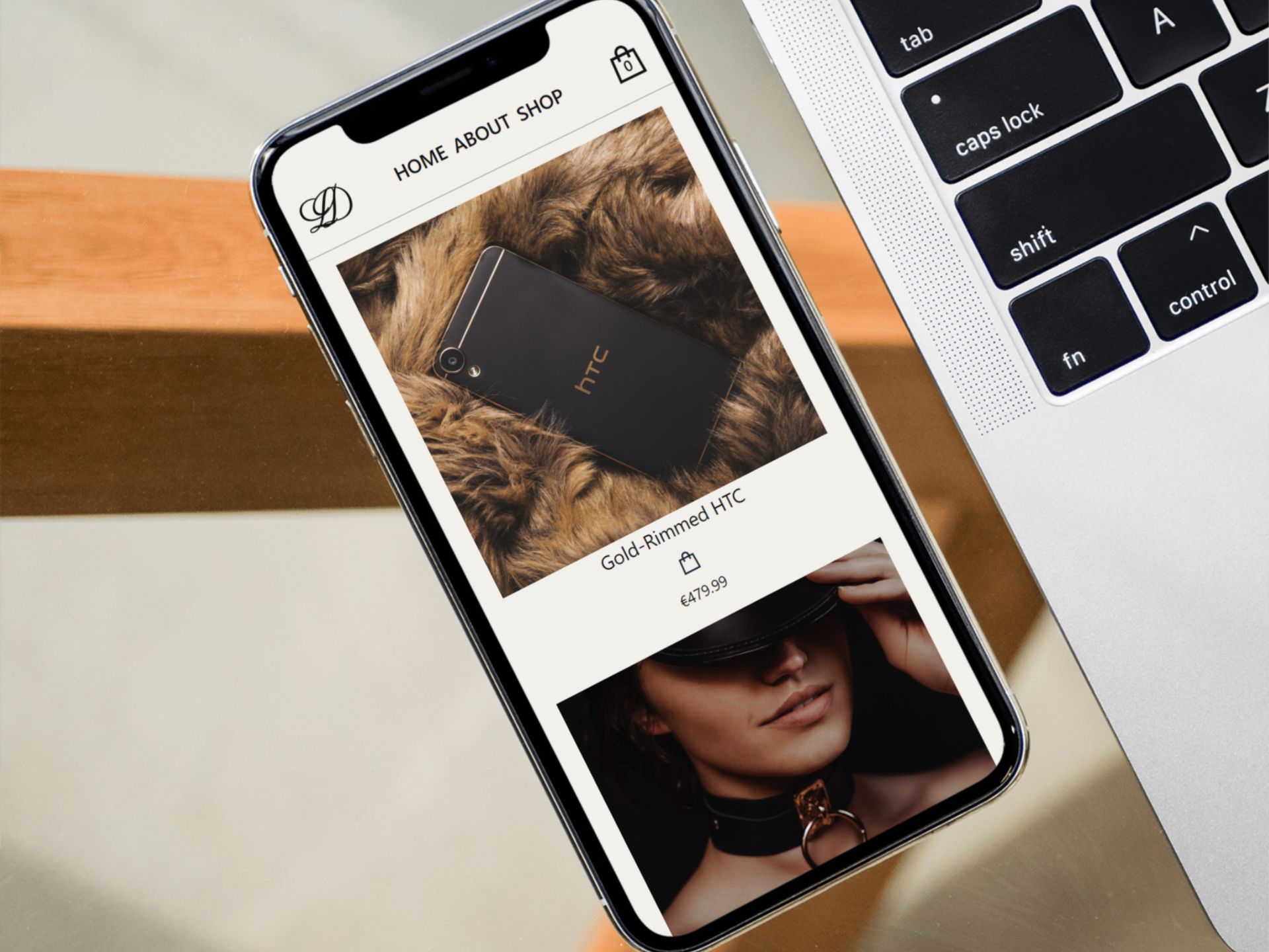A luxury e-commerce site on a HTC phone, resting next to a laptop, both on a table